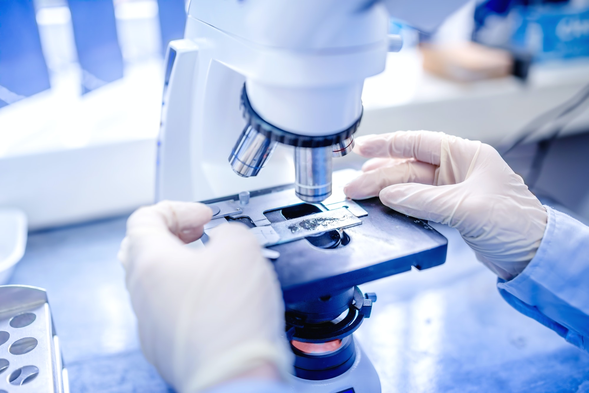 scientist-hands-with-microscope-examining-samples-and-liquid-medical-research.jpg